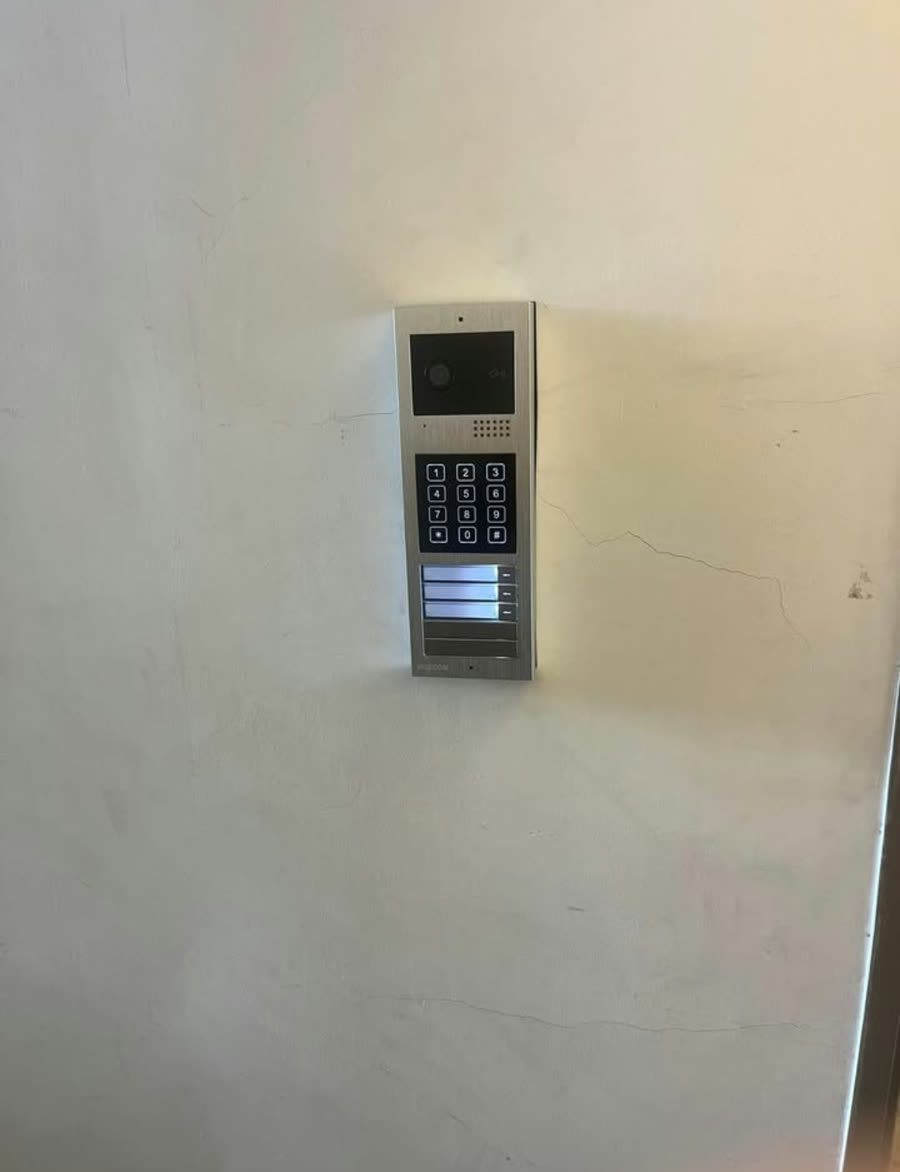 עמדת אינטרקום עם מקלדת על קיר לבן
